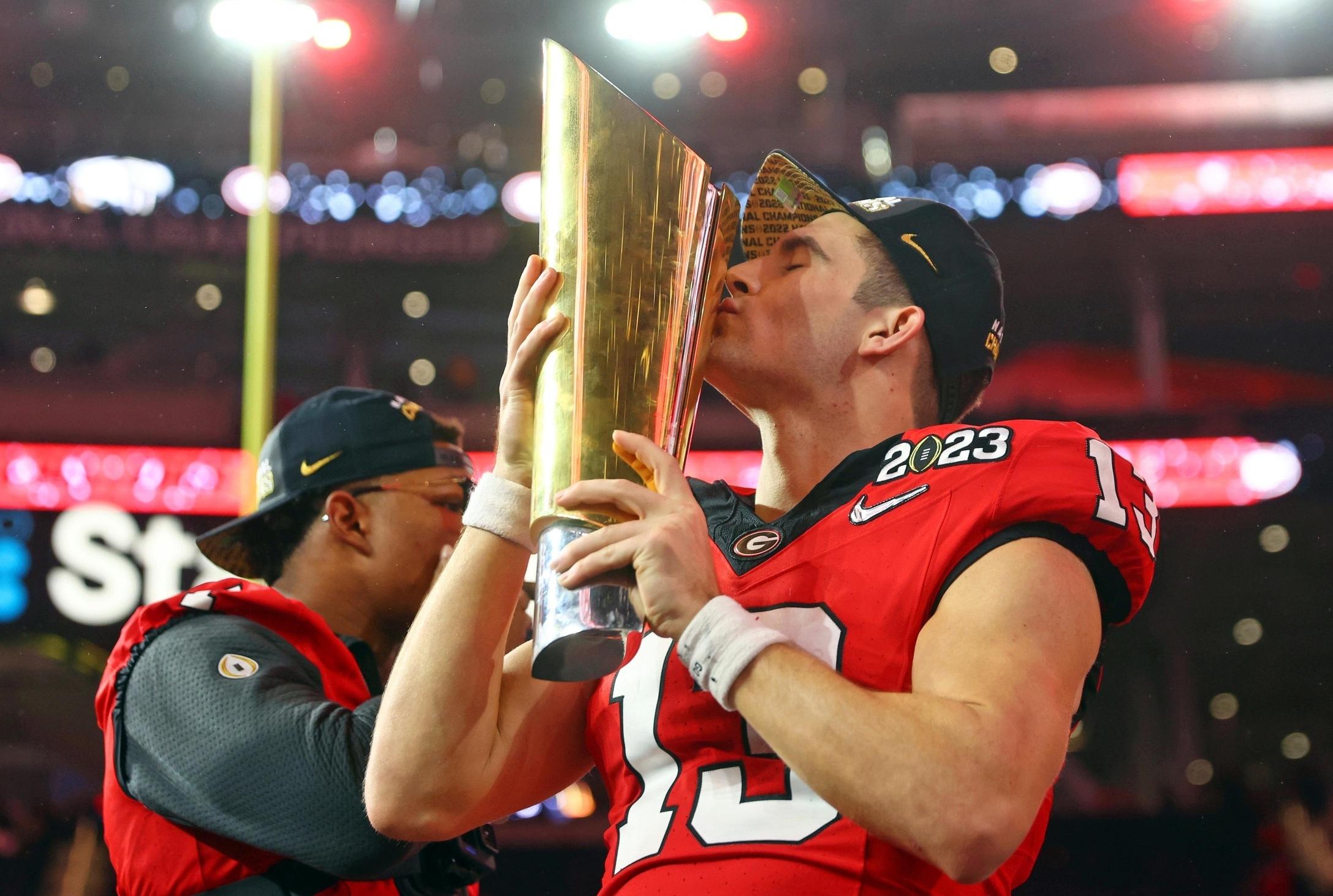 Stetson Bennett of Georgia kisses the CFP national championship trophy after beating TCU.