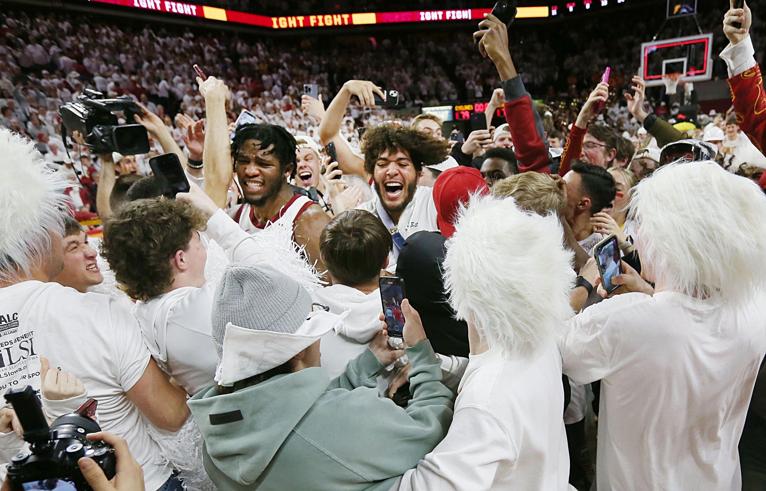 Iowa State fans rush the court and celebrate with players after beating Kansas