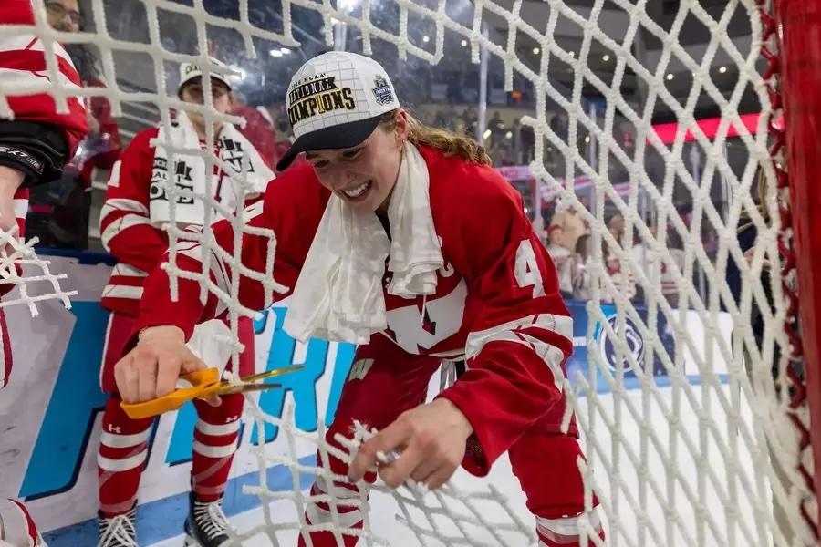 Caroline Harvey cuts down the net after winning the 2026 NC women's ice hockey championship